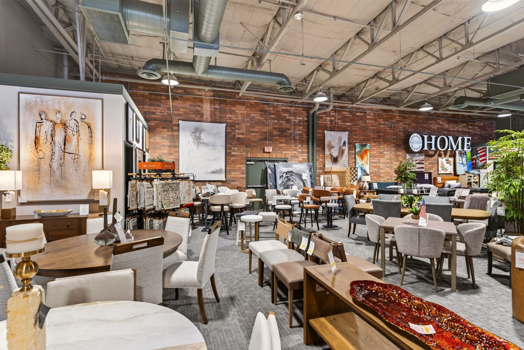 Dining tables and chairs across the open floor of a furniture showroom